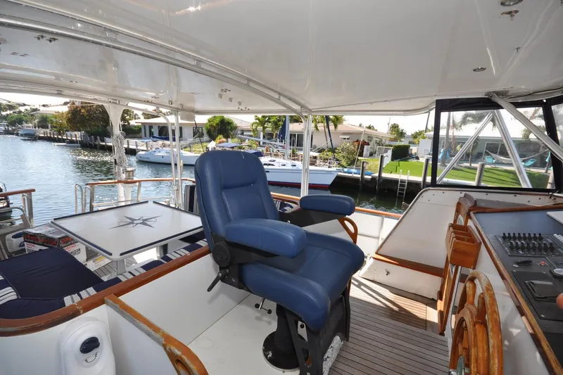 In The Flow Yacht Photos Pics Luxurious 1982 Custom Virpack Steelhull yacht interior with blue captain's chair and waterfront view.