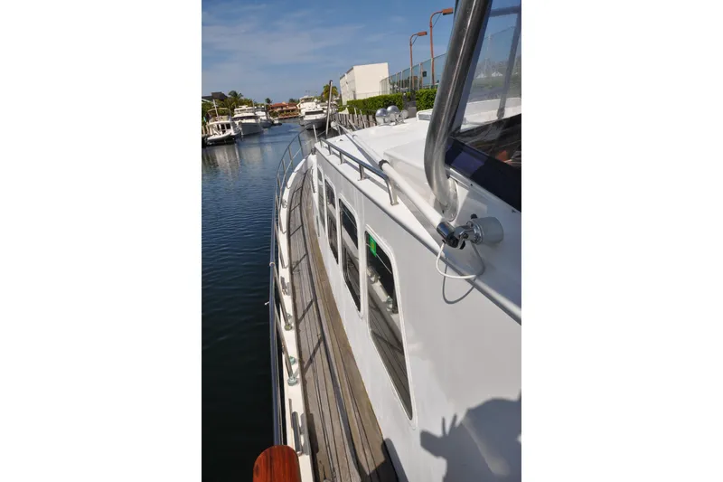 In The Flow Yacht Photos Pics Custom 1982 Virpack Steelhull yacht docked in a serene marina setting.