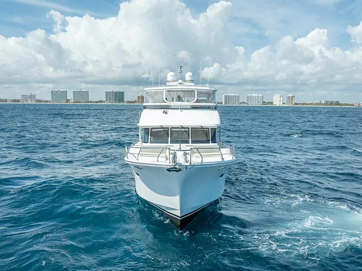Sunny Seajay Yacht Photos Pics 2022 Hampton 658l Endurance yacht cruising on open sea with city skyline backdrop.