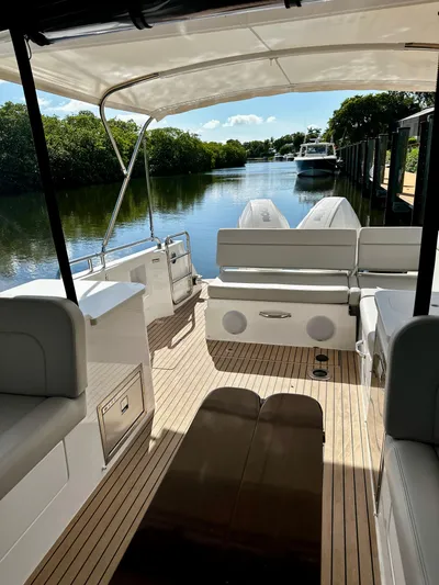 Key East Yacht Photos Pics 2023 MJM 3 boat interior with canopy, docked on a serene river.