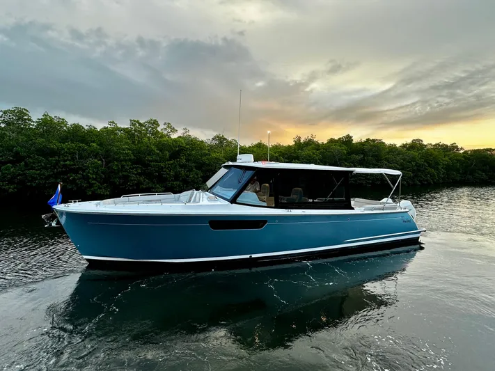 Key East Yacht Photos Pics 2023 MJM 3 boat cruising on a serene river at sunset.
