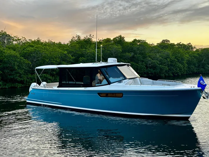 Key East Yacht Photos Pics 2023 MJM 3 boat cruising on calm water at sunset.