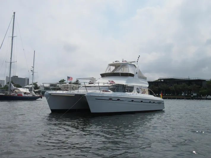 Africa 3 Yacht Photos Pics Africat Marine 420 yacht from 2008 on calm waters, with flags and marina backdrop.