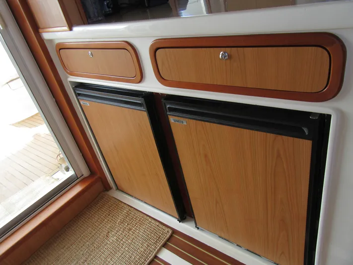 Africa 3 Yacht Photos Pics Wood-paneled cabinets and mini-fridges in 2008 Africat Marine 420 yacht interior.