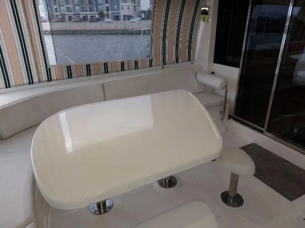 Titan 46 Yacht Photos Pics Luxurious Leopard 46 yacht interior with sleek white table, striped curtains, and waterfront view.