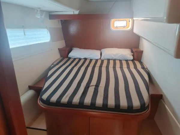 Titan 46 Yacht Photos Pics Cozy cabin interior of 2011 Leopard 46 yacht with striped bedding and porthole window.