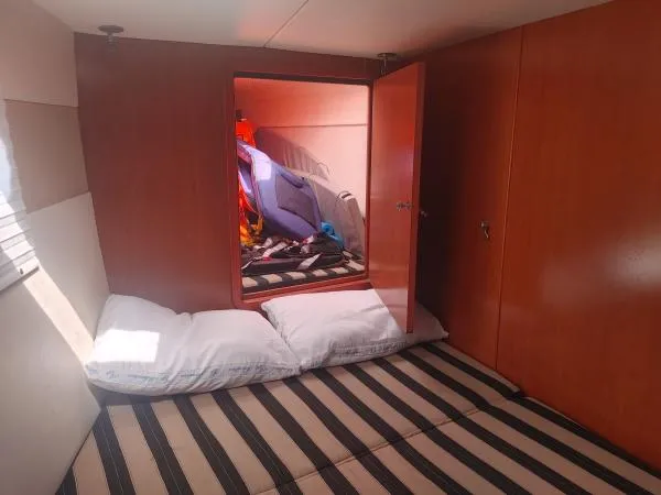 Titan 46 Yacht Photos Pics Cozy cabin interior of 2011 Leopard 46 yacht with striped bedding and open storage.