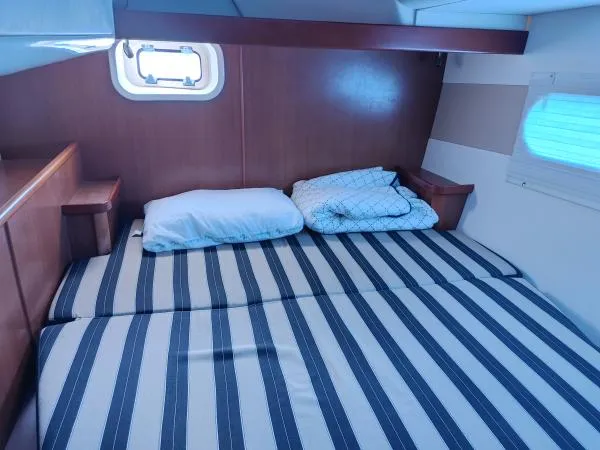 Titan 46 Yacht Photos Pics Cozy cabin bedroom in 2011 Leopard 46 yacht with striped bedding and wooden accents.