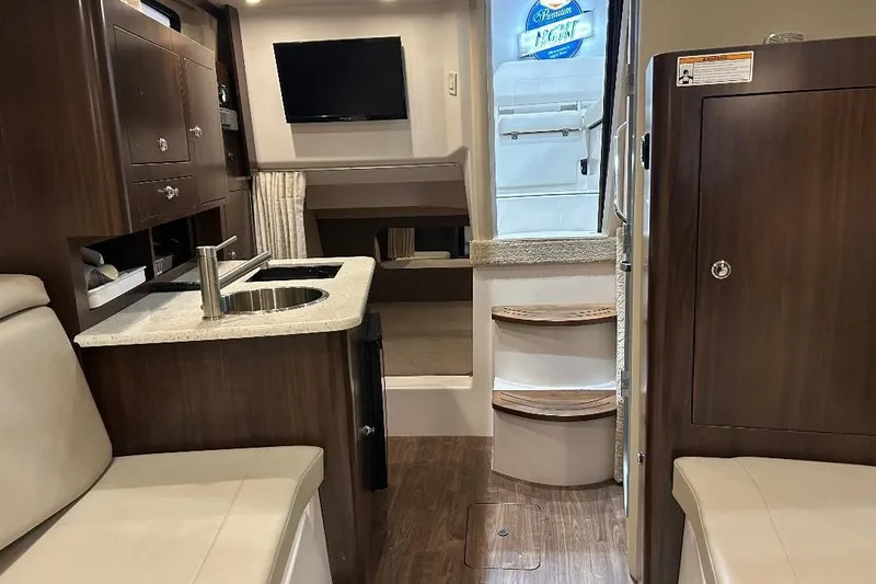  Yacht Photos Pics Interior of 2017 Regal 30 Express boat with kitchenette, seating, and steps to deck.