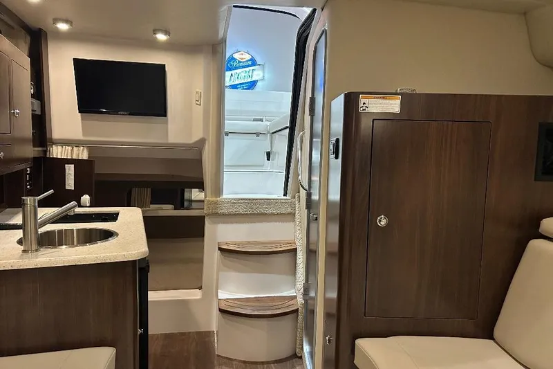  Yacht Photos Pics Interior of 2017 Regal 30 Express boat with kitchenette, TV, and seating area.