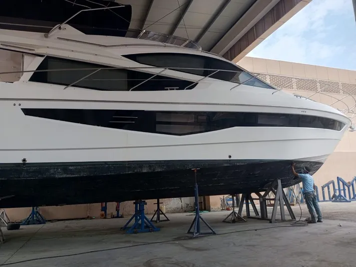 Sadeen Yacht Photos Pics 2016 Galeon 550 Fly yacht under maintenance in a covered facility.