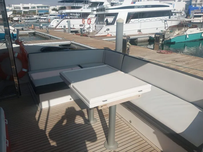 Sadeen Yacht Photos Pics Outdoor seating area on a 2016 Galeon 550 Fly yacht, docked at a marina.
