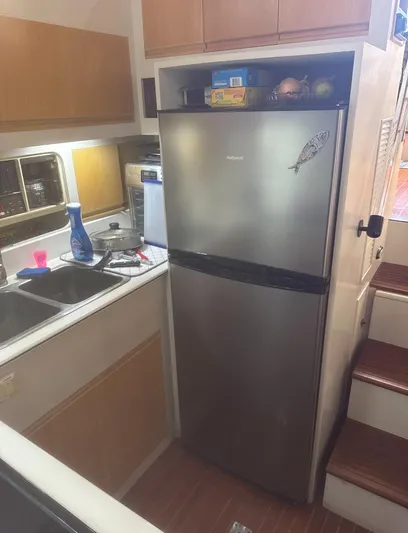  Yacht Photos Pics Compact kitchen area in a 1994 President 445 Sundeck yacht with stainless steel fridge.