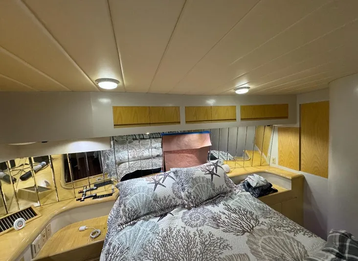  Yacht Photos Pics Cozy bedroom interior of 1994 President 445 Sundeck yacht with nautical-themed bedding.