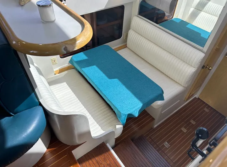  Yacht Photos Pics Interior of 1994 President 445 Sundeck yacht with white seating and blue table cover.