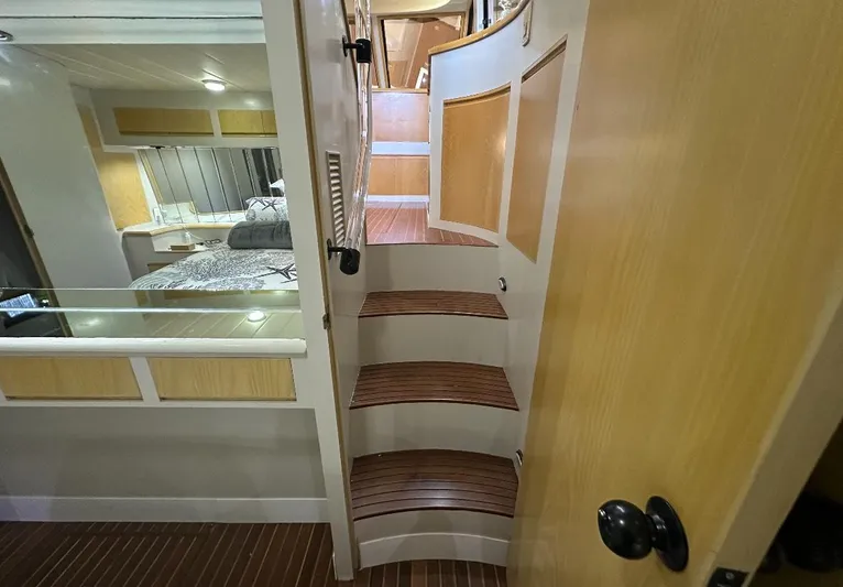  Yacht Photos Pics Interior of 1994 President 445 Sundeck yacht with wooden stairs and cozy cabin.