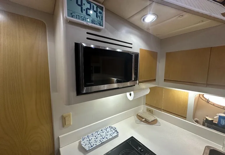  Yacht Photos Pics Compact kitchen area in a 1994 President 445 Sundeck yacht with microwave and clock.