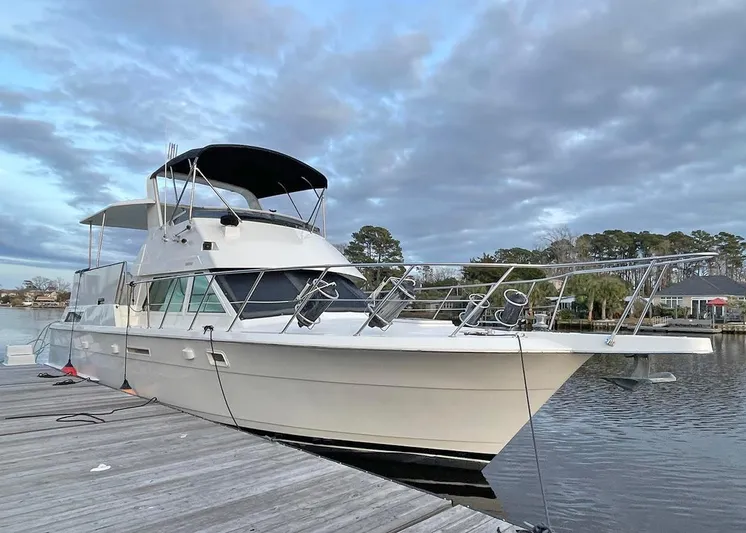 New Moon Yacht Photos Pics 1996 Hatteras 42 CPMY yacht docked by a serene waterfront.