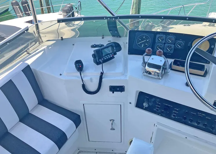 New Moon Yacht Photos Pics Cockpit of 1996 Hatteras 42 CPMY with striped seating and navigation controls.