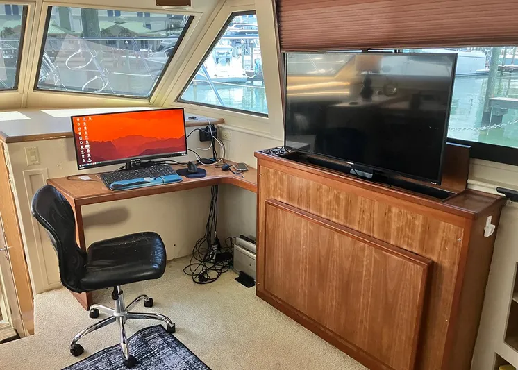 New Moon Yacht Photos Pics Office setup inside 1996 Hatteras 42 CPMY yacht with desk, chair, computer, and TV.