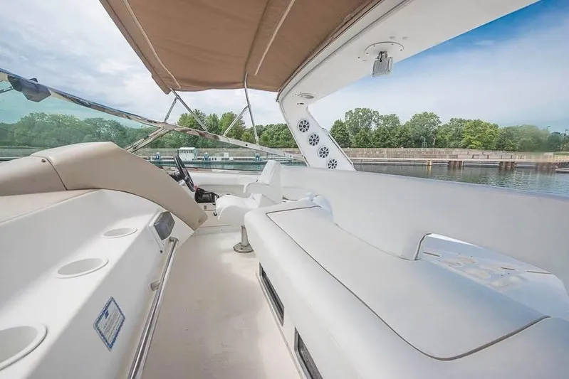  Yacht Photos Pics 1998 Sea Ray 500 Sundancer yacht interior with spacious seating and canopy, docked by a serene waterfront.