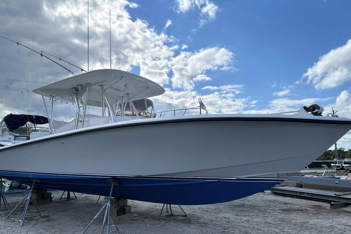 1999 Venture 34 Open boat on stands, under a partly cloudy sky.