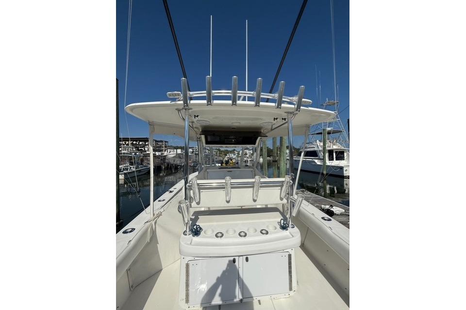 1999 Venture 34 Open boat with rod holders, docked at a marina under clear blue skies.