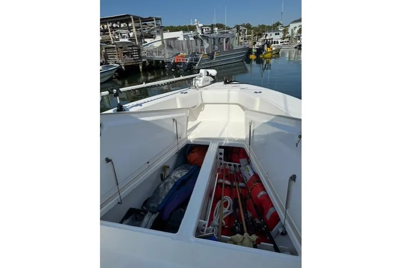  Yacht Photos Pics 1999 Venture 34 Open boat with open storage compartments at a marina.