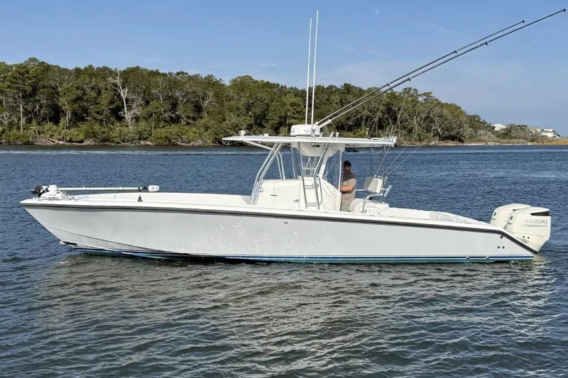  Yacht Photos Pics 1999 Venture 34 Open boat on calm water with trees in the background.