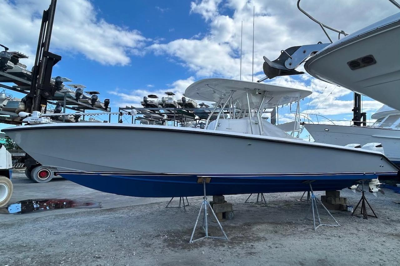 1999 Venture 34 Open boat on stands, under a blue sky with clouds.