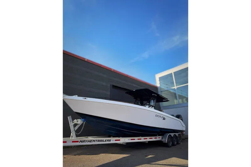  Yacht Photos Pics 2006 Donzi 35 ZF Cuddy boat on trailer, parked outdoors under clear sky.
