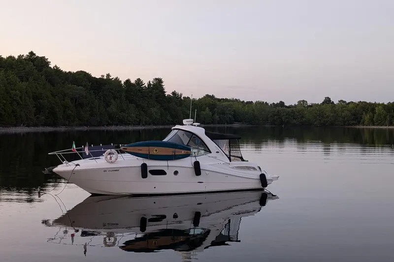  Yacht Photos Pics 2012 Sea Ray 350 Sundancer yacht on calm lake with forested shoreline.