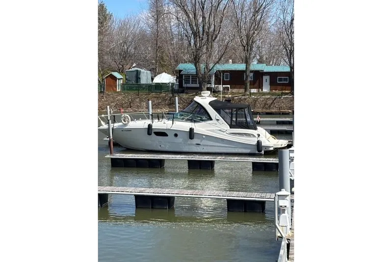  Yacht Photos Pics 2012 Sea Ray 350 Sundancer docked at marina, surrounded by trees and cabins.