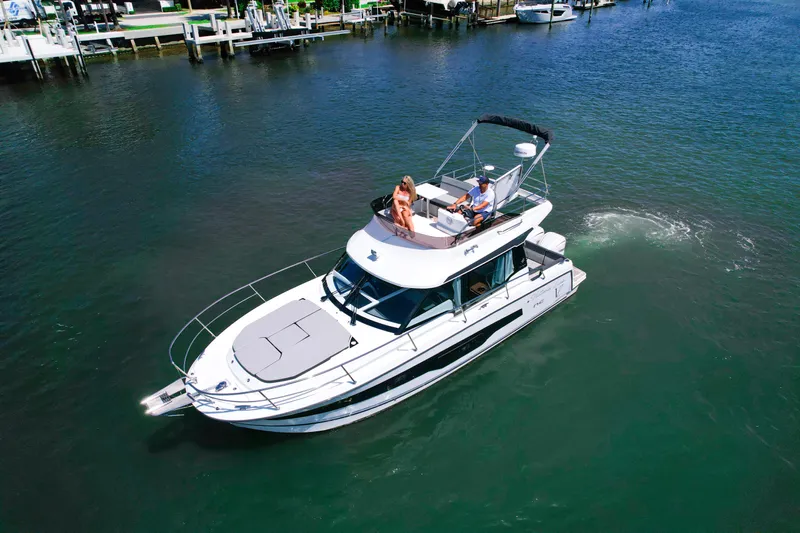  Yacht Photos Pics 2024 Jeanneau NC1095 Fly yacht cruising on a sunny day in calm waters.