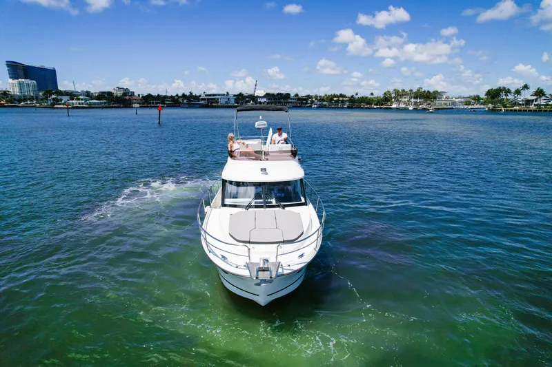  Yacht Photos Pics 2024 Jeanneau NC1095 Fly cruising on a sunny day, with passengers enjoying the view.