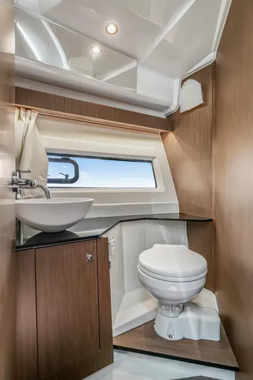 Yacht Photos Pics 2024 Jeanneau NC1095 Fly bathroom with modern fixtures and wood accents.