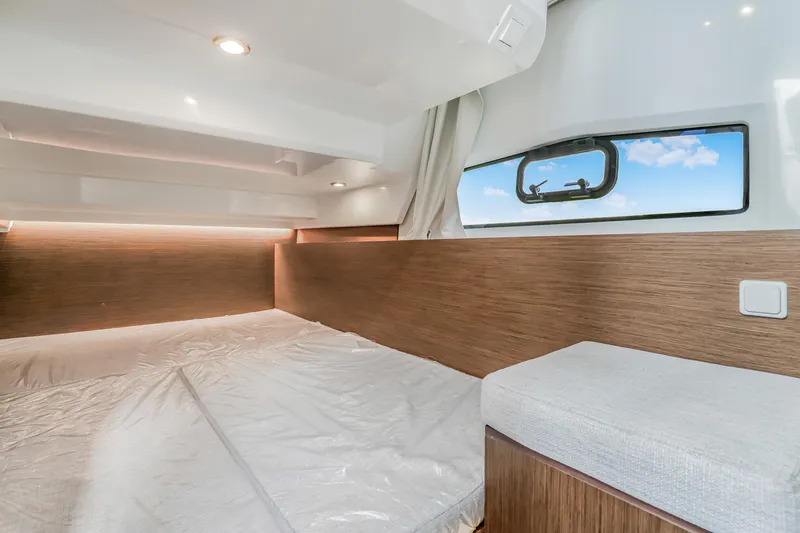  Yacht Photos Pics 2024 Jeanneau NC1095 Fly cabin interior with modern wood finish and window view.