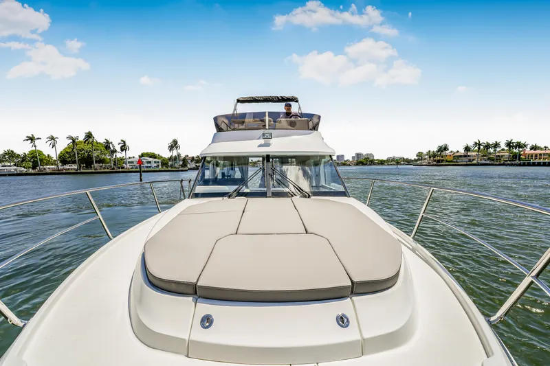  Yacht Photos Pics 2024 Jeanneau NC1095 Fly yacht cruising on a sunny day, featuring spacious deck and flybridge.