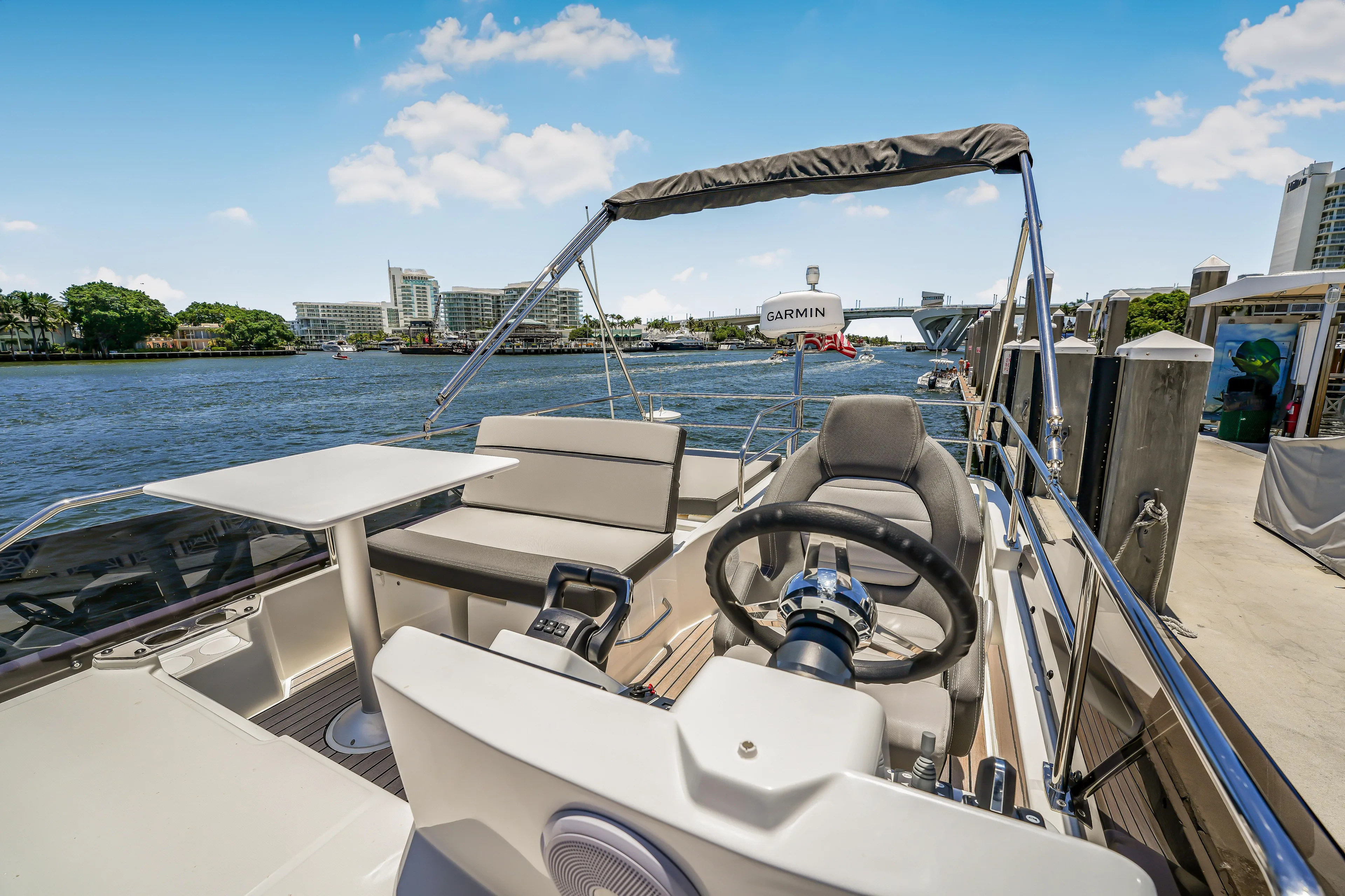  Yacht Photos Pics 2024 Jeanneau NC1095 Flybridge with helm, seating, and table, docked by waterfront.