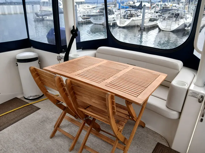 Blind Squirel Yacht Photos Pics 2006 Silverton 35 Motor Yacht interior with wooden table and chairs, marina view.