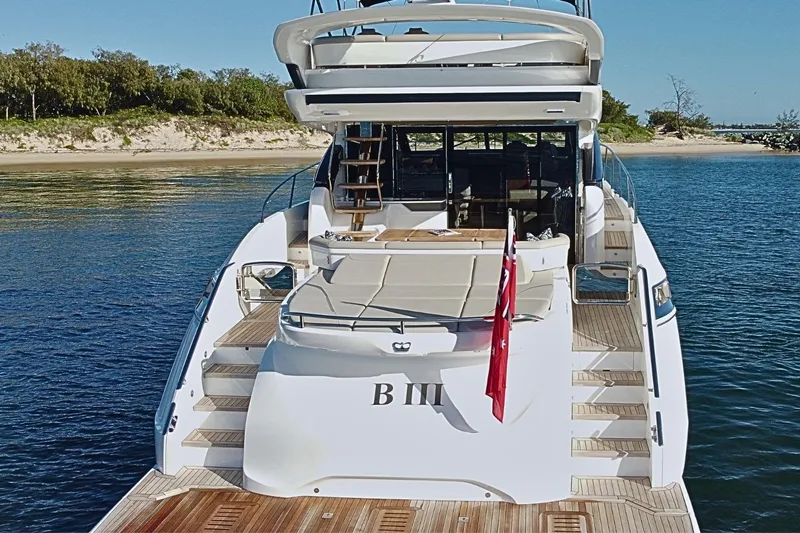 B III Yacht Photos Pics Luxury 2021 Princess S62 yacht docked by a scenic shoreline.