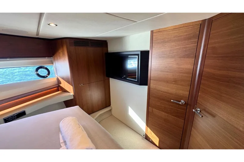 B III Yacht Photos Pics Luxurious cabin interior of 2021 Princess S62 yacht with wood paneling and window view.