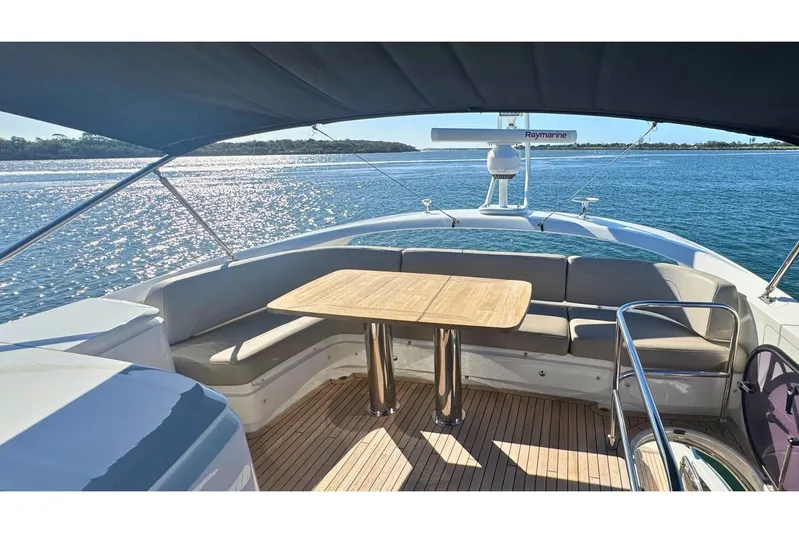 B III Yacht Photos Pics Luxurious 2021 Princess S62 yacht deck with seating and table, overlooking serene waters.