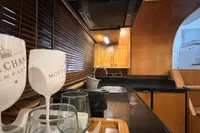 Luxurious kitchen interior of 2007 Trader 42 HT yacht with wooden cabinetry and champagne glasses.