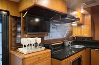 Luxurious 2007 Trader 42 HT yacht kitchen with wood cabinetry, TV, and modern amenities.