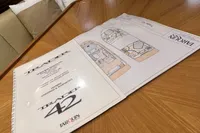 Blueprints and documents for 2007 Trader 42 HT yacht on a wooden table.