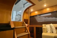 Interior of 2007 Trader 42 HT yacht with wooden stairs and cozy seating area.