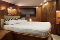 Luxurious bedroom interior on a 2007 Trader 42 HT yacht, featuring wood paneling and ambient lighting.