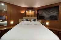 Luxurious cabin interior of 2007 Trader 42 HT yacht with cozy bed and ambient lighting.