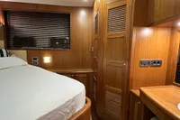 Luxurious wooden interior of 2007 Trader 42 HT yacht cabin with bed and storage.